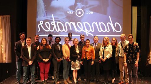 Students and faculty posing on stage at the Changemaker Challenge.